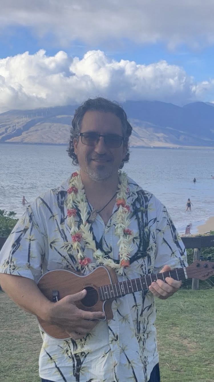 Aaron AZ Grzanich playing ukulele by the ocean in Maui